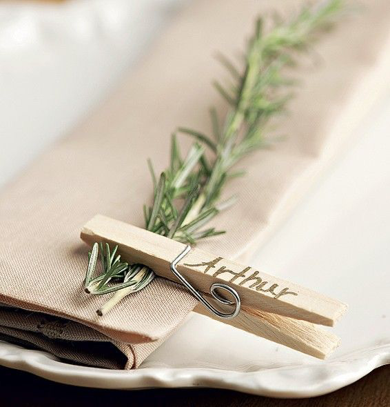 Pinza de madera con nombre colocada en una servilleta de tela beige